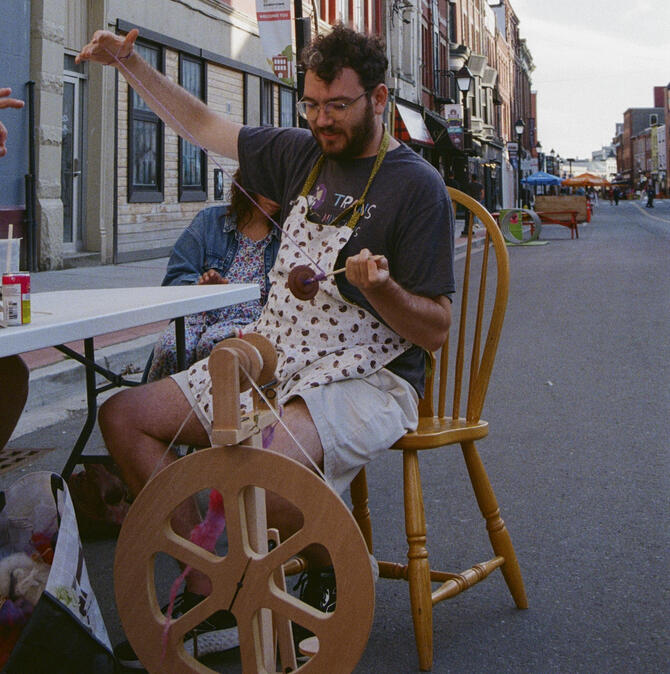 Christian giving a spinning demo on a drop spindle